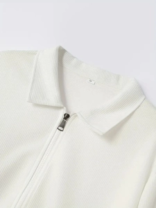 Dettaglio della giacca polo in maglia a costine bianca con zip a un quarto e revers