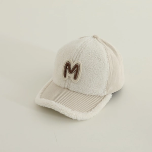 Detailed close-up of M letter patch on thick corduroy and sherpa fleece baseball cap
