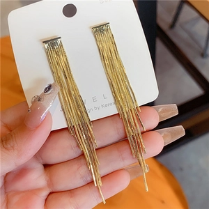 Macro shot of gold tassel heart earrings featuring 925 silver needle dangling chains