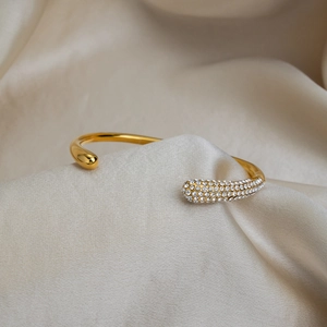 Detailed macro view of 18K gold plated bangle with pave crystals and drop design