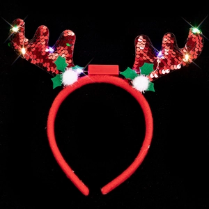 Detail of glowing Christmas reindeer antlers headband with festive LED lights and red sequins