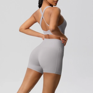 Close-up of light gray yoga set with cross-back sports bra and high-waist side pocket shorts