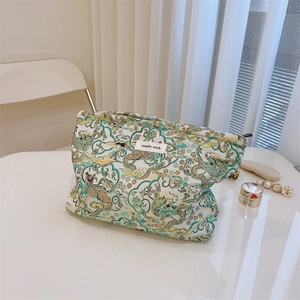 Detail of teal and gold jacquard makeup bag with traditional dragon pattern and woven label