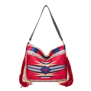 Close-up of bohemian red woven shoulder bag with ethnic patterns and long side tassels