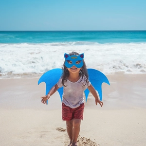 Blue felt bat wings and mask set for kids shown during outdoor beach cosplay play