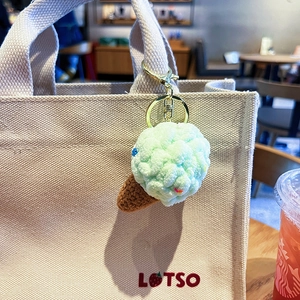 Cute knitted mint ice cream keychain accessory with golden clasp on a canvas bag handle