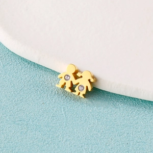 Gros plan détaillé de boucles d'oreilles garçon et fille dorées avec petit diamant