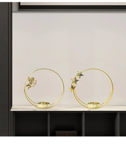 Detail of golden circle angel and star candle holders on marble surface décor