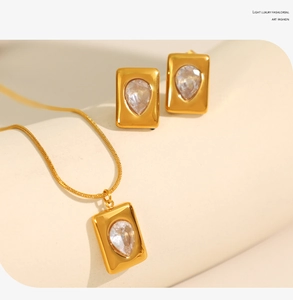 Detail of the 18K gold plated jewelry set featuring emerald green teardrop gemstones