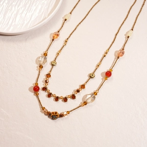 Vintage layered beaded necklace with floral metal accents in warm earthy brown and gold tones