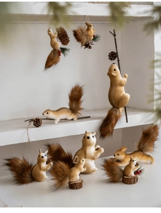 Detailed view of lifelike squirrel ornaments with fur texture, pine cones and red berries
