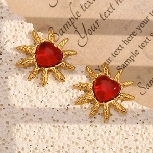 Macro shot of 18K gold plated heart earrings with sunburst texture and red agate