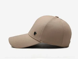 Side view of light khaki cotton baseball cap with a metal shield logo and fine stitching