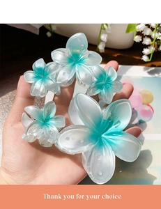 Detail of blue and white gradient plumeria flower hair claws in small and large sizes