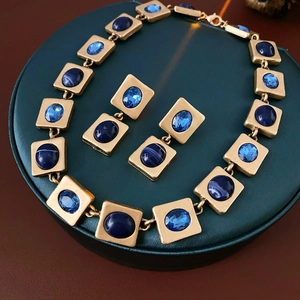 Makroansicht von Vintage-Halskette und blauen Edelsteinohrringen auf einer Box