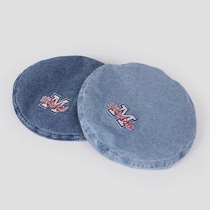 Detailed close-up of washed denim beret featuring vintage Madrid letter patches