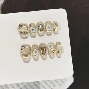 Champagne gold press-on nails with 3D white flowers and sparkling rhinestones