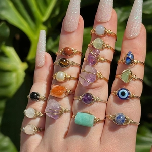Détail de bagues artisanales en fil doré avec agate verte naturelle et pierres précieuses