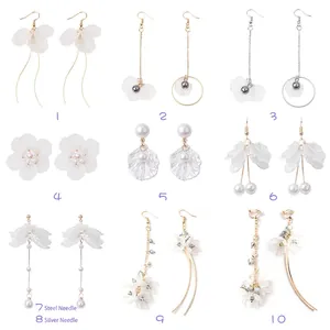 Lot de 10 boucles d'oreilles fleurs ivoire avec perles et cristaux sur fond blanc pur