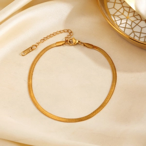 Elegant gold stainless steel snake chain anklet with lobster clasp on silk background