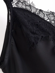 Dettaglio del bordo in pizzo sul décolleté in tessuto di raso nero da donna