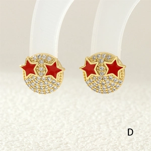 Detail of 18K gold smiley earring with micro-pave zircons and red enamel stars
