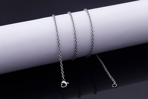 Macro view of polished silver tassel chain links and lobster clasp on jewelry