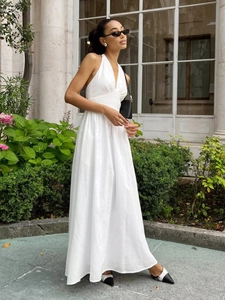 Detail of elegant white halter neck maxi dress with deep V-neck and flowing skirt