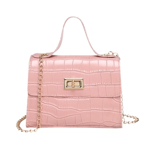 Pink faux crocodile leather trapezoid crossbody bag with gold-tone twist-lock and chain strap