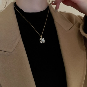 Détail d'un collier pendentif perle avec halo de zircons porté par un mannequin