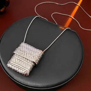 Square woven texture pendant necklace with silver snake chain displayed on black stand