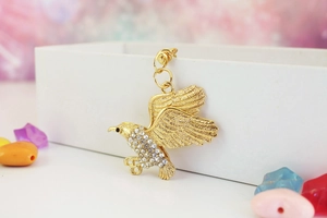 Detailaufnahme des goldenen Adler-Schlüsselanhängers mit schimmernden Strasssteinen
