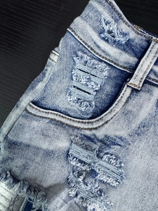 Dettaglio ravvicinato di pantaloncini di jeans blu chiaro con bordi sfrangiati e strappi