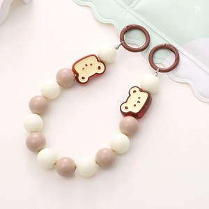 Colorful acrylic beaded phone chain with cute bear charms and dual rings on a clean surface