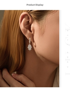 Détail macro d'une boucle d'oreille Main de Fatma en argent avec zircons
