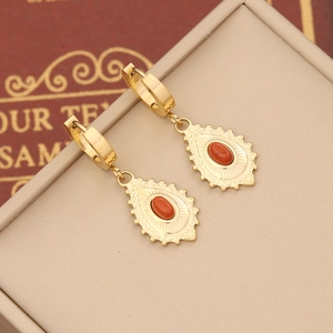 Detail shot of vintage bohemian earrings with red stones in gold stainless steel frames