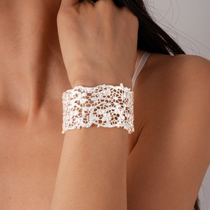 Detail shot of wide silver open cuff bracelet with intricate hollow lace pattern on wrist