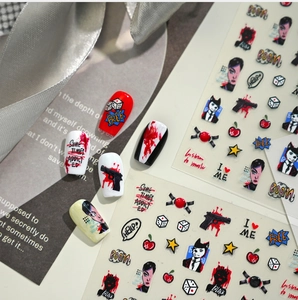 Macro detail of punk art nail stickers with red and black comic motifs on magazine background
