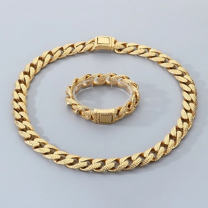 Detail view of golden textured Cuban link necklace and bracelet set on a display