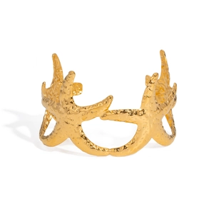 Bracelet jonc ouvert étoile de mer dorée avec texture marine sur fond blanc épuré