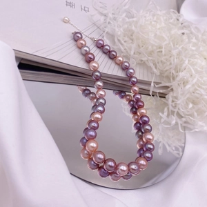 Detailed close-up of multi-color baroque pearls with S925 silver clasp on a mirror