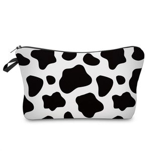 Detail of multi-functional cow print pouch featuring a sturdy zipper and side carry handle