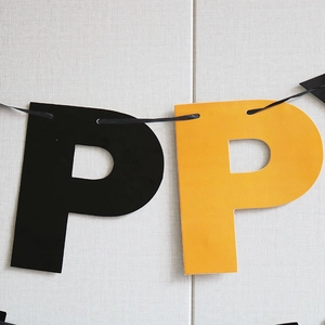 Close-up of orange and black paper flags with the letter P for Halloween party banner