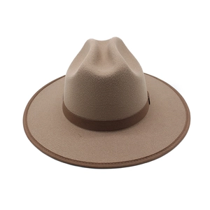 Detail of a camel wool fedora hat with a brown decorative band and structured wide brim