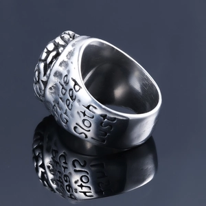 Macro view of stainless steel ring showing engraved sins like pride and greed on the side