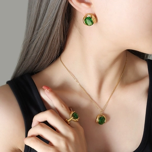 Vintage emerald crystal jewelry set with gold necklace, earrings and ring on model
