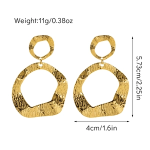 Détail de grandes créoles géométriques plaquées or 18 carats avec texture métal martelé