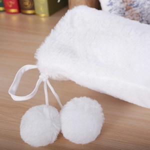 White plush Christmas stocking gift bag with drawstrings and fluffy pompom decorations