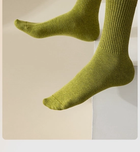 Detail of model wearing yellow-green mid-calf cotton socks in a clean lifestyle setting