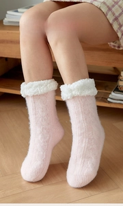 Close-up of pink cable knit thermal socks with thick white faux shearling lining